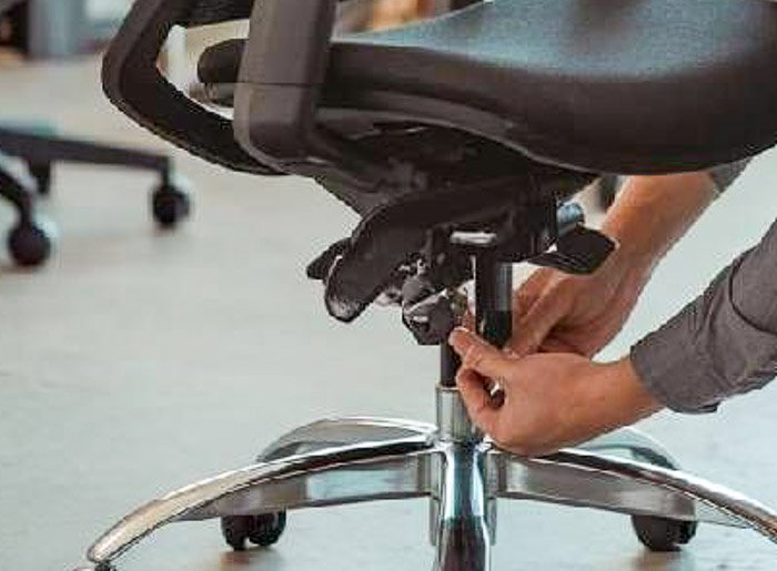 technician performing gas lift maintenance on office chair